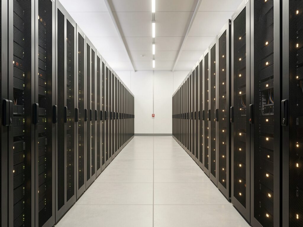 A clean, modern data centre with orderly rows of server cabinets.